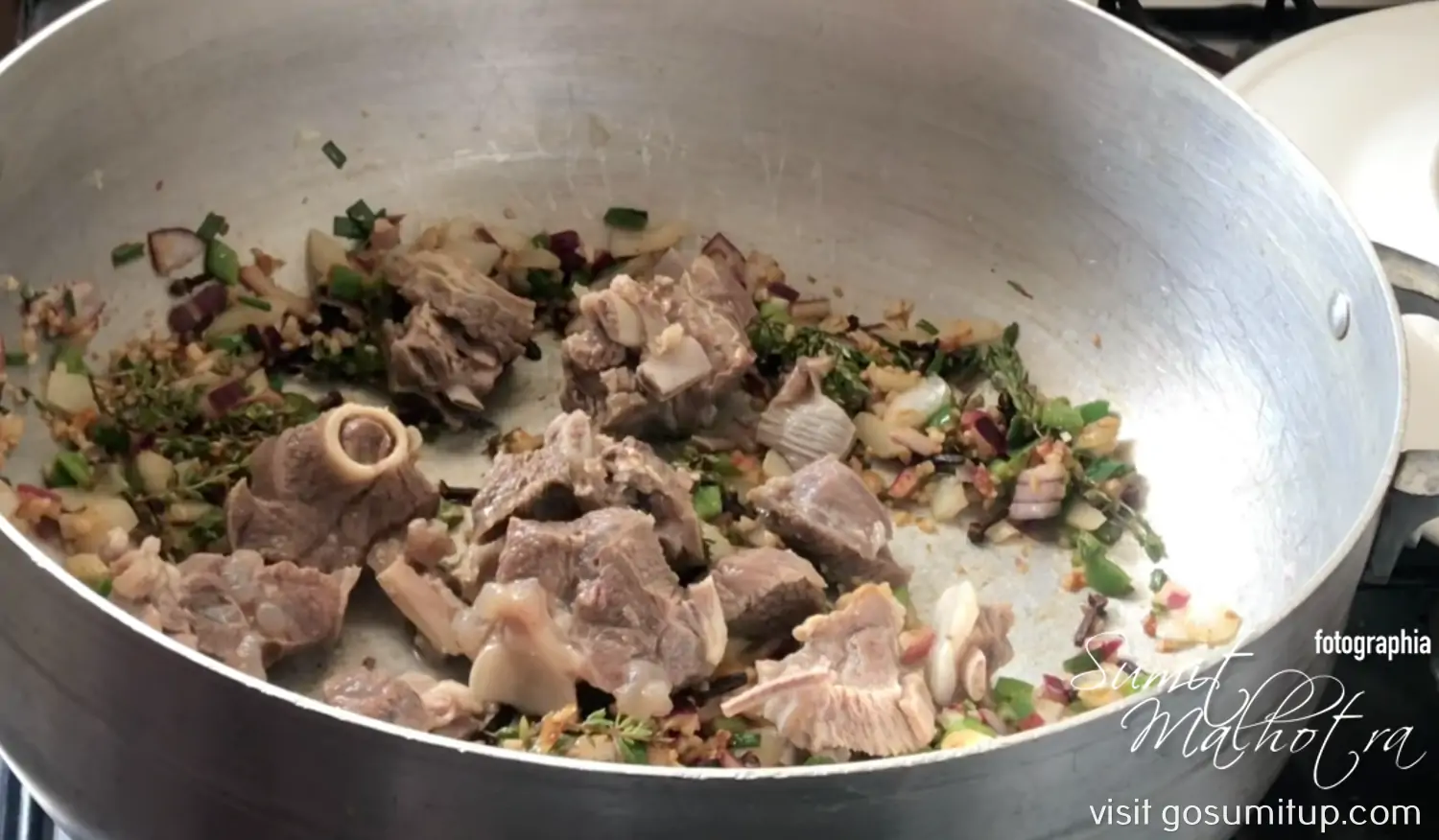 Mutton being browned with seasoning & vegetables