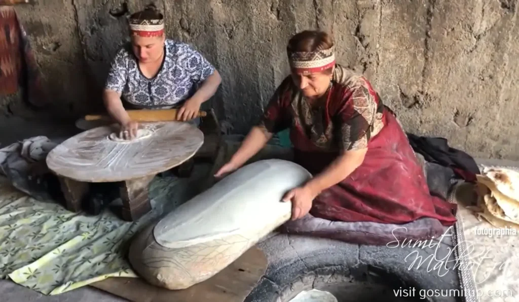 Ladies baking lavash in a tonir oven