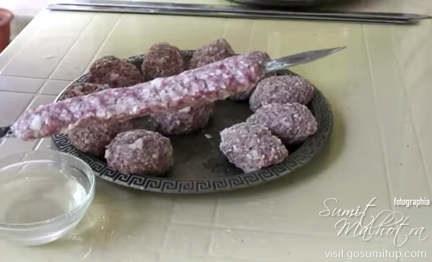 Place the minced meat balls on a flat skewer and form a cylinder Place the minced meat balls on a flat skewer and form a cylinder