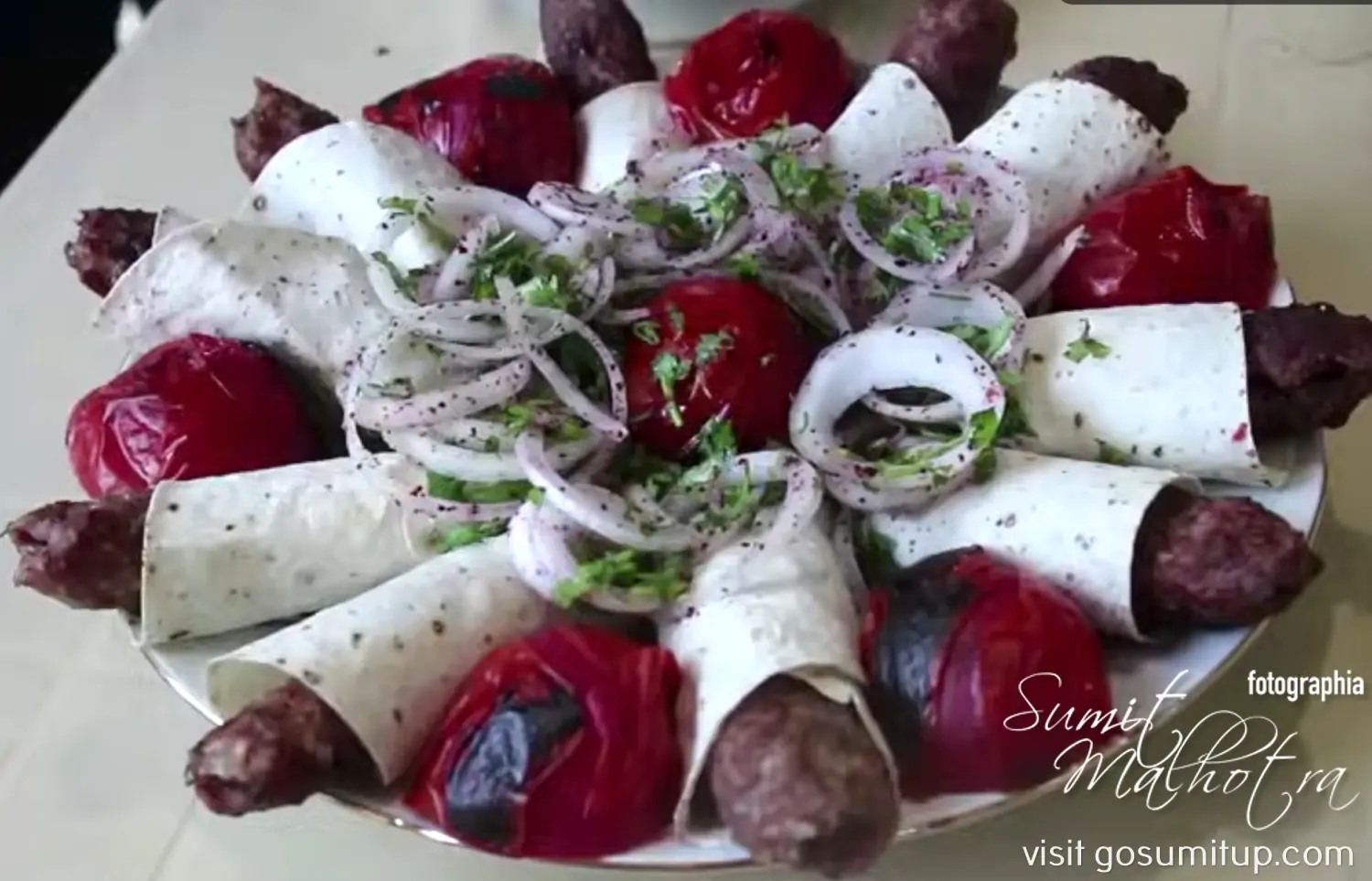 Serve Lula Kabab Wrapped in Lavash with Grilled Tomatoes & Raw Red Onions, Parsley or Dill , Dusted with Sumac